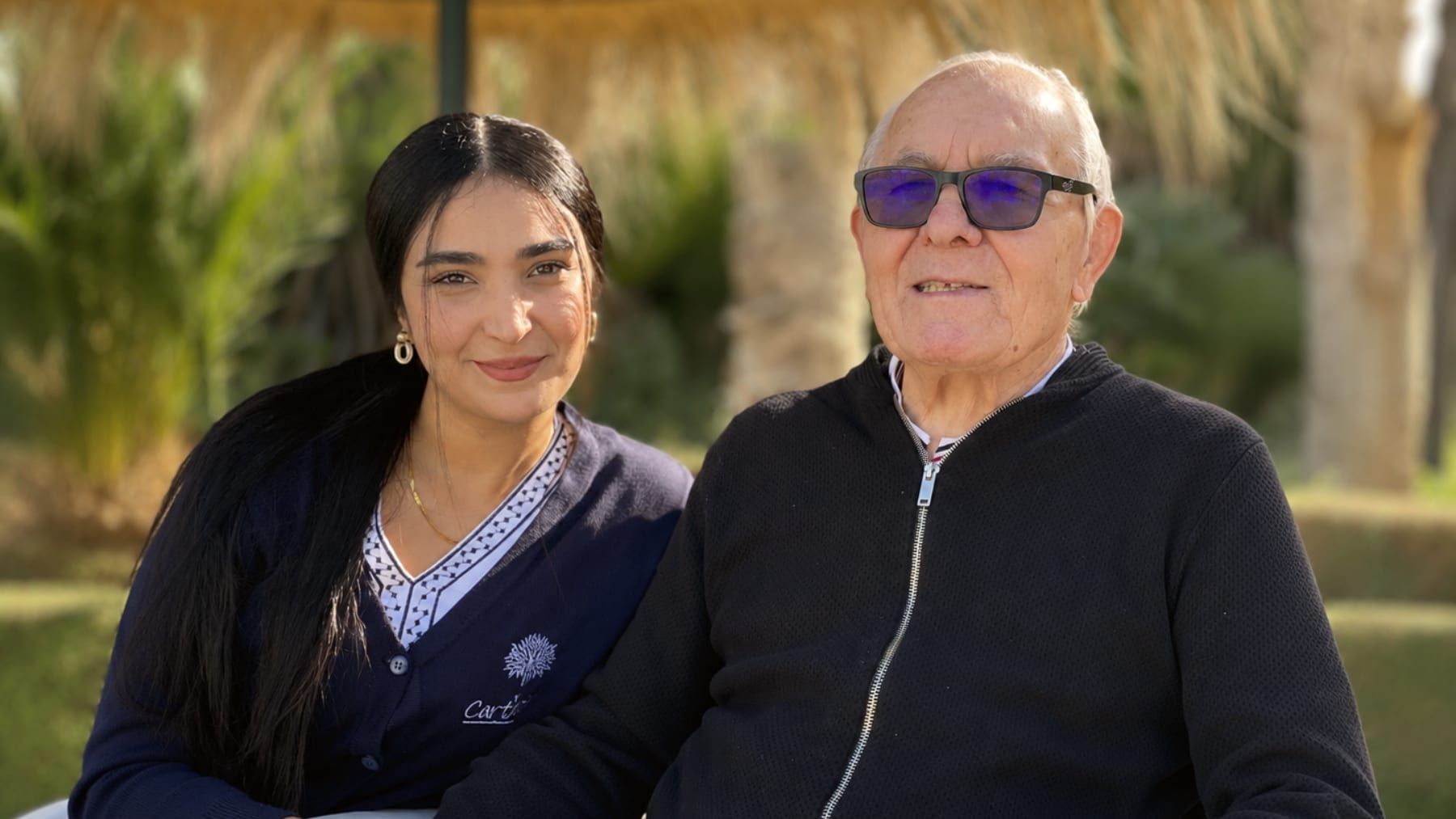 Une aide-soignante et un résident dans les jardins
